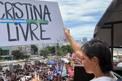 Mayra Mendoza en Río de Janeiro pidiendo por Cristina Kirchner libertad total junto a una bandera.