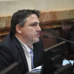 Senador Francisco Paoltroni explicando detalles sobre su crédito hipotecario del Banco Ciudad en su despacho.