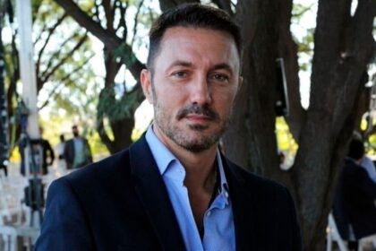 Luis Petri sostiene un mate con la inscripción Milei 2027 en una muestra de Luis Petri apoya a Milei.